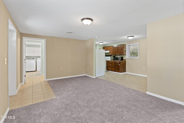 interior space featuring light carpet and washer and clothes dryer