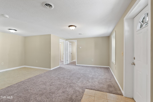 carpeted spare room with a textured ceiling