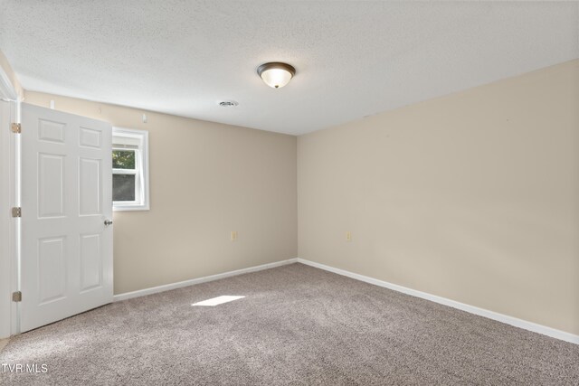 carpeted spare room with a textured ceiling