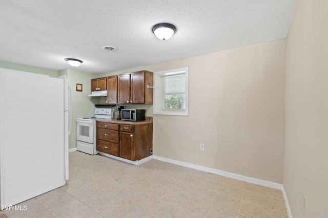 kitchen featuring a textured ceiling and white appliances