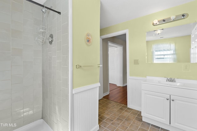 bathroom with vanity and a tile shower