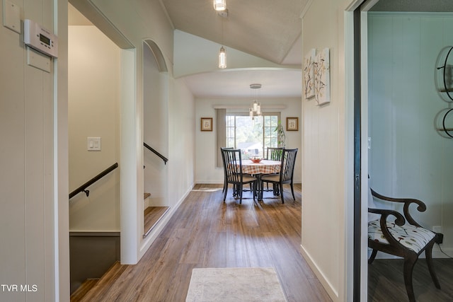 hallway featuring vaulted ceiling and light hardwood / wood-style flooring