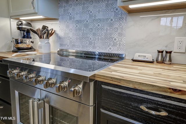kitchen with backsplash, wooden counters, and range with two ovens