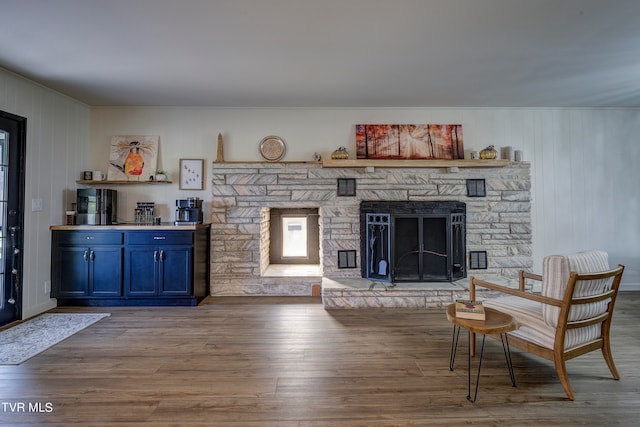 living room with a fireplace and wood-type flooring