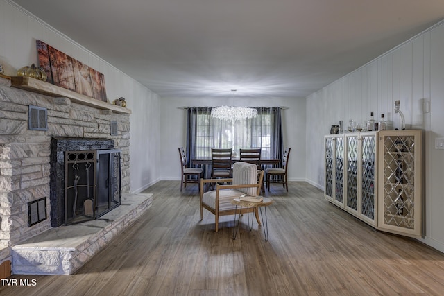 dining area featuring visible vents, baseboards, a notable chandelier, wood finished floors, and a stone fireplace