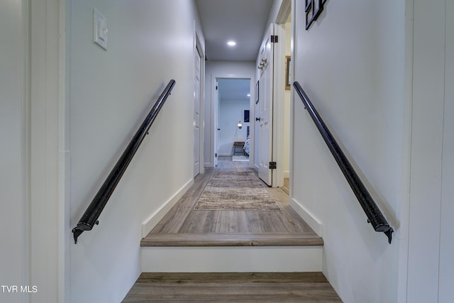staircase with wood finished floors and recessed lighting