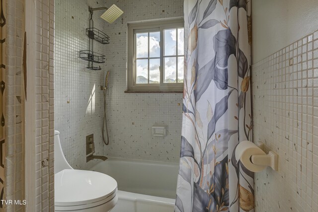 bathroom featuring toilet and shower / bath combo with shower curtain