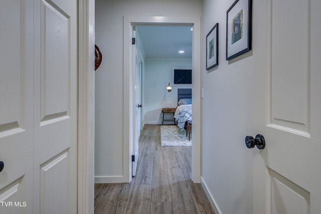 hall with ornamental molding and light wood-type flooring