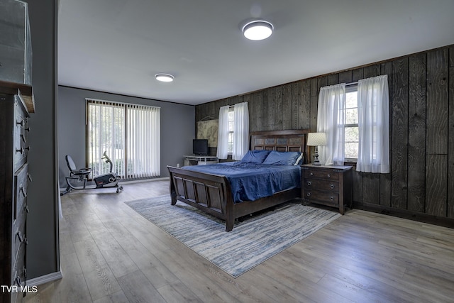 bedroom with wood walls and wood finished floors