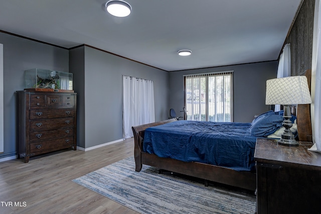 bedroom with light hardwood / wood-style floors and ornamental molding