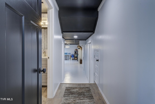 hallway with wood finished floors and baseboards