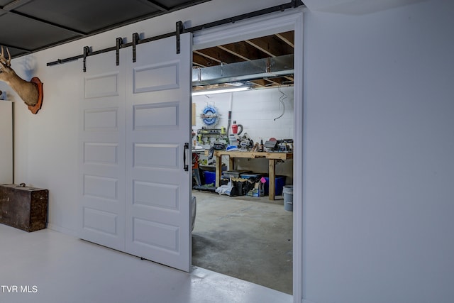 basement with a barn door and a workshop area