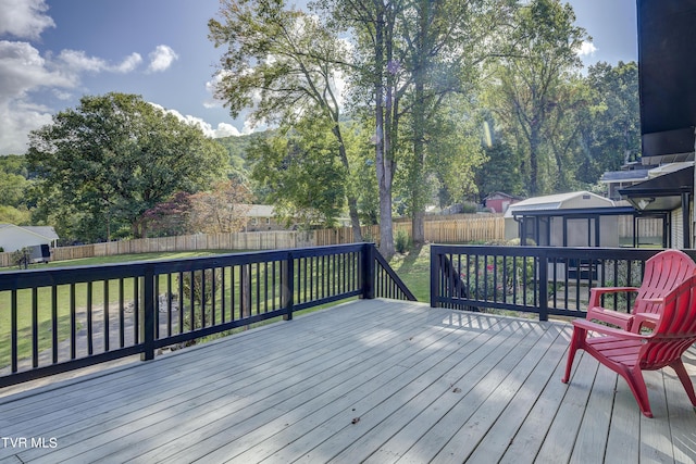 wooden terrace featuring a fenced backyard, a sunroom, and a yard