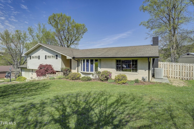ranch-style house with a chimney, a front lawn, a shingled roof, fence, and brick siding
