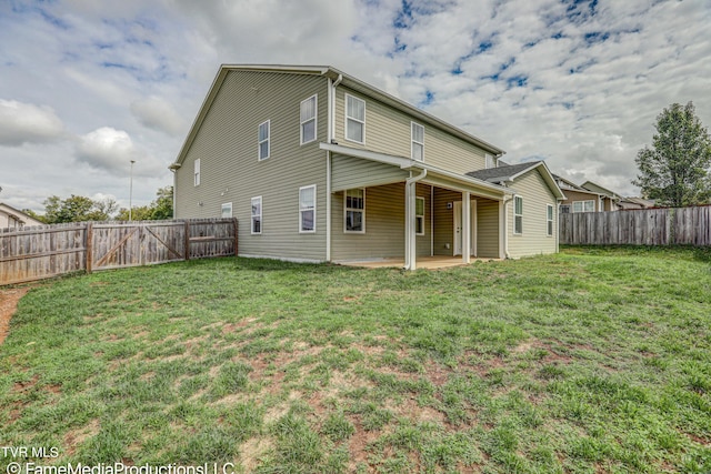 rear view of house featuring a patio and a yard