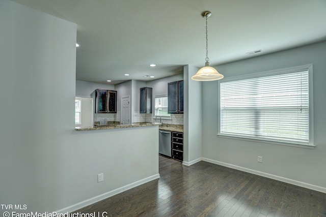 kitchen with stainless steel dishwasher, dark hardwood / wood-style floors, kitchen peninsula, and a healthy amount of sunlight