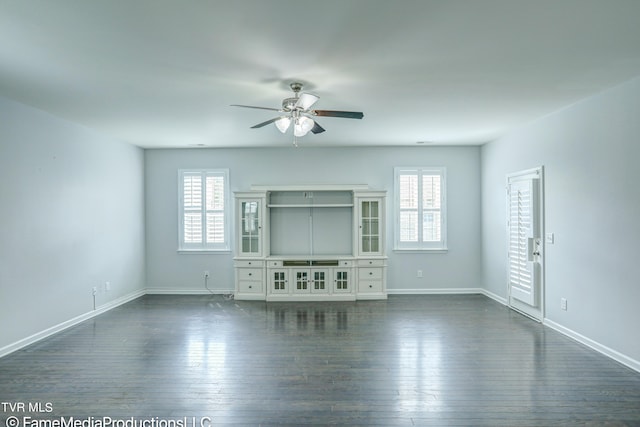 unfurnished living room with a healthy amount of sunlight, dark hardwood / wood-style floors, and ceiling fan