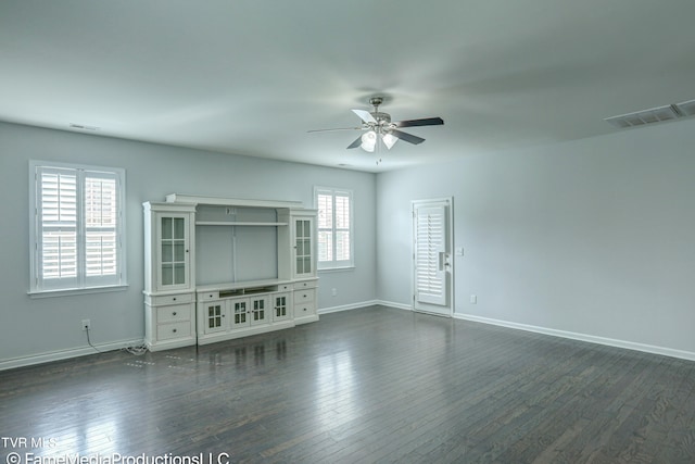 unfurnished living room with dark hardwood / wood-style floors, ceiling fan, and plenty of natural light