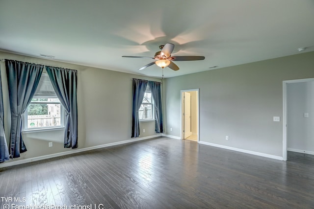 spare room featuring dark wood-type flooring, ceiling fan, and a wealth of natural light