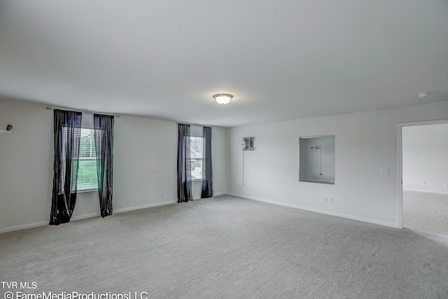 unfurnished room featuring light colored carpet and electric panel