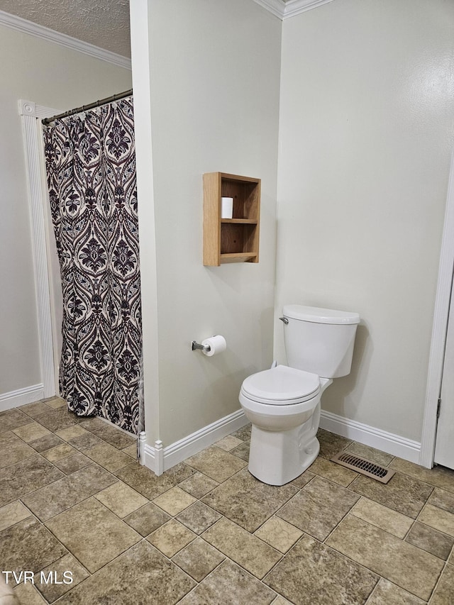 bathroom with a textured ceiling, toilet, and ornamental molding