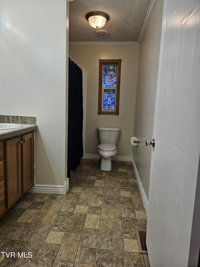 bathroom featuring vanity, toilet, a textured ceiling, and ornamental molding