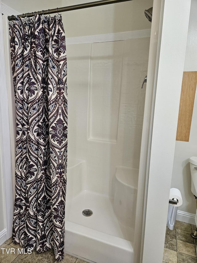 bathroom featuring toilet, curtained shower, and crown molding