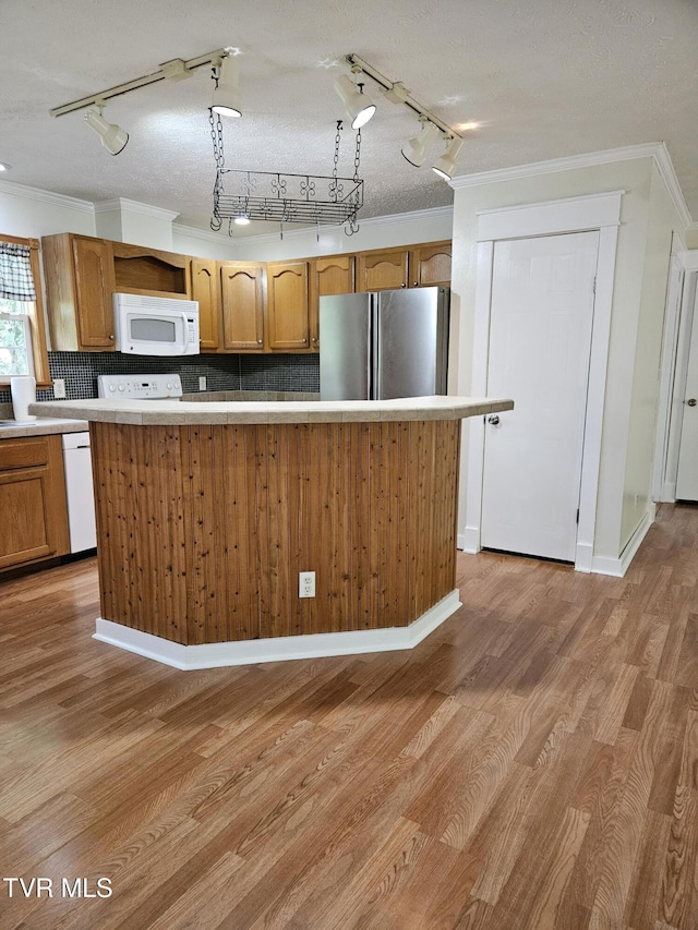 kitchen with light hardwood / wood-style floors, a textured ceiling, white appliances, a kitchen island, and decorative backsplash