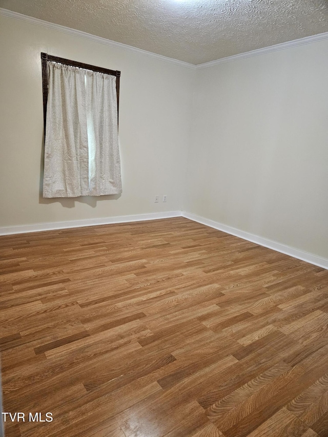 unfurnished room featuring light wood-type flooring, a textured ceiling, and crown molding