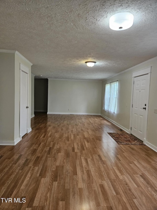 unfurnished room with ornamental molding, hardwood / wood-style floors, and a textured ceiling