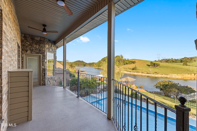 balcony with a water view and ceiling fan