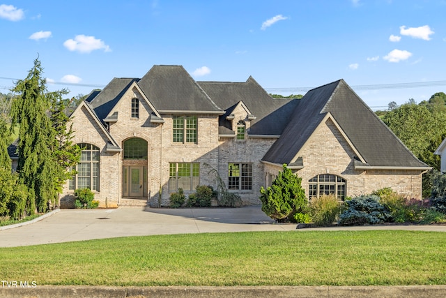 french country inspired facade featuring a front yard