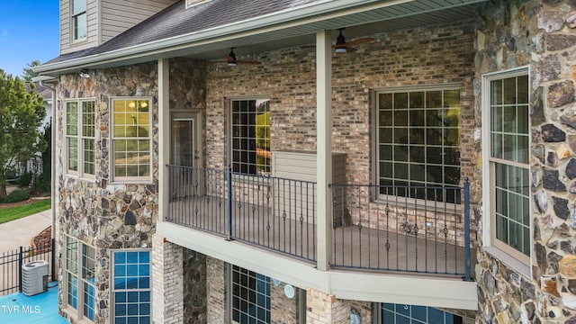 view of side of property with ceiling fan and a balcony