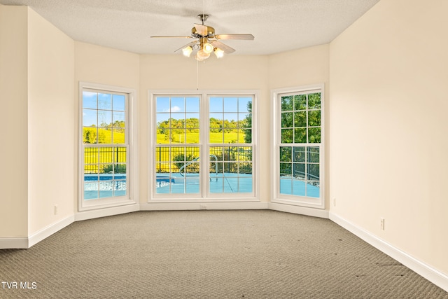 unfurnished room featuring ceiling fan, carpet flooring, and a textured ceiling