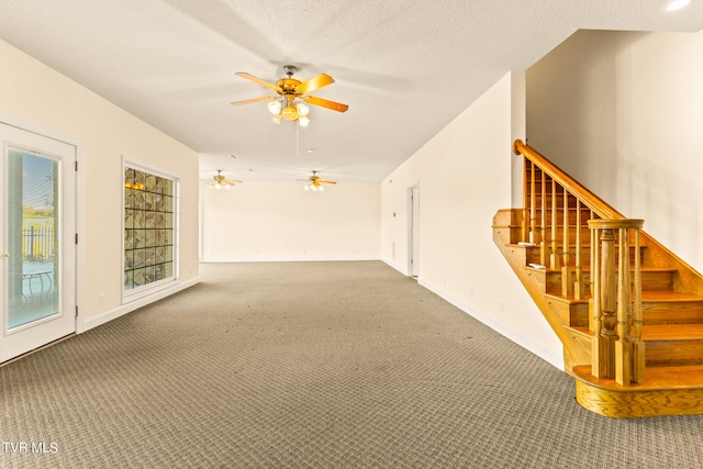 empty room featuring carpet floors, ceiling fan, and a textured ceiling