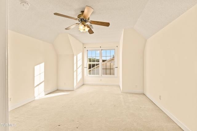 additional living space with light carpet, ceiling fan, vaulted ceiling, and a textured ceiling