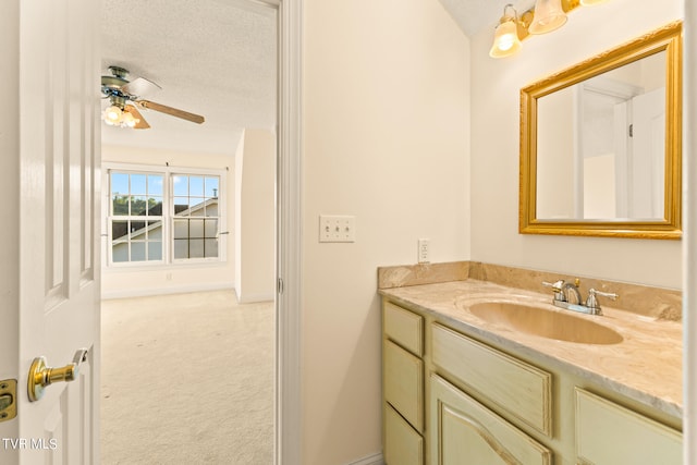 bathroom featuring ceiling fan, vanity, and a textured ceiling