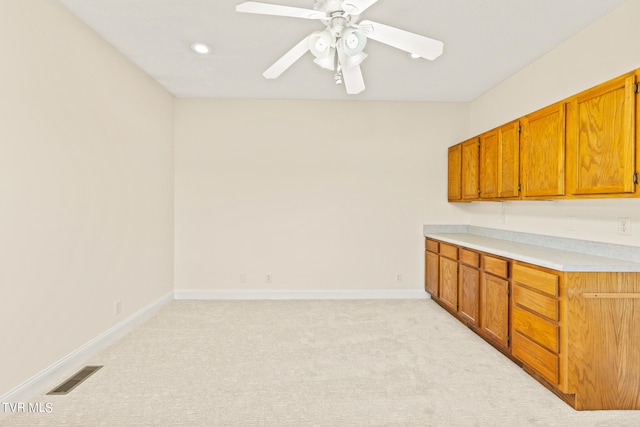 kitchen with ceiling fan and light colored carpet