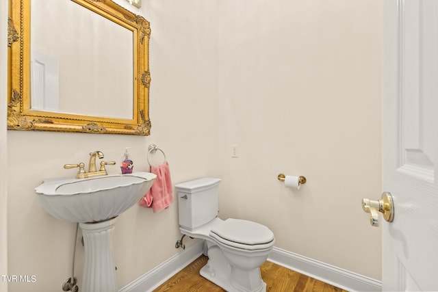 bathroom with hardwood / wood-style floors and toilet