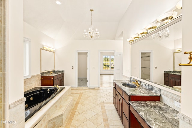 bathroom featuring lofted ceiling, tile patterned floors, a relaxing tiled tub, and vanity