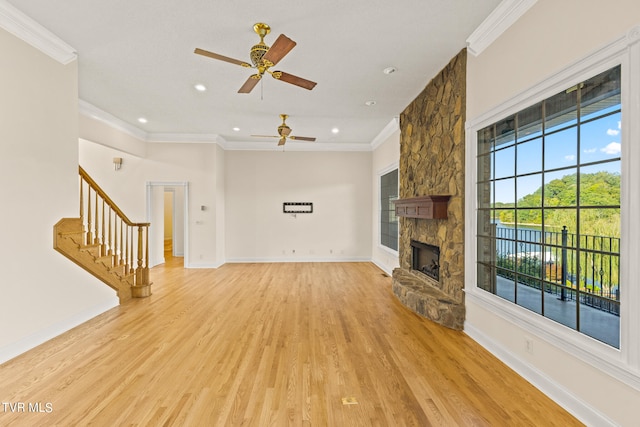 unfurnished living room featuring a fireplace, ornamental molding, light wood-type flooring, and ceiling fan