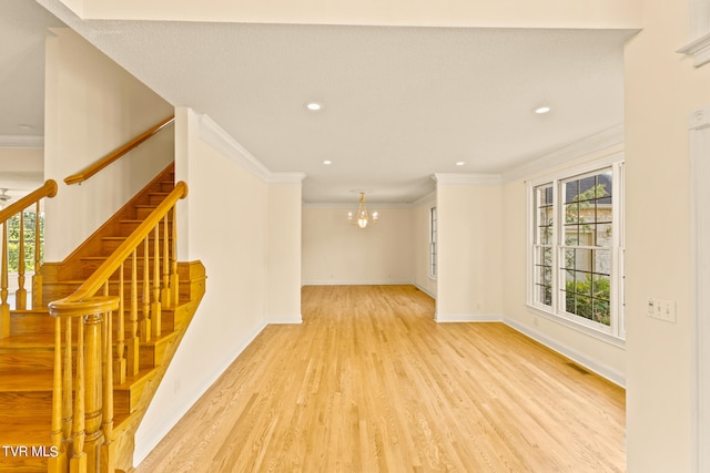 interior space with crown molding, a chandelier, and light wood-type flooring