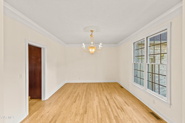 spare room with a textured ceiling, crown molding, an inviting chandelier, and light hardwood / wood-style flooring