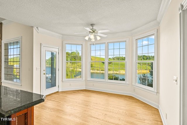 unfurnished sunroom featuring ceiling fan