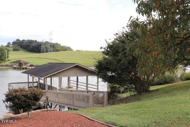 exterior space with a deck with water view and a lawn