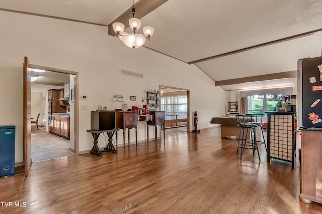 dining area featuring an inviting chandelier, lofted ceiling with beams, and light wood-type flooring