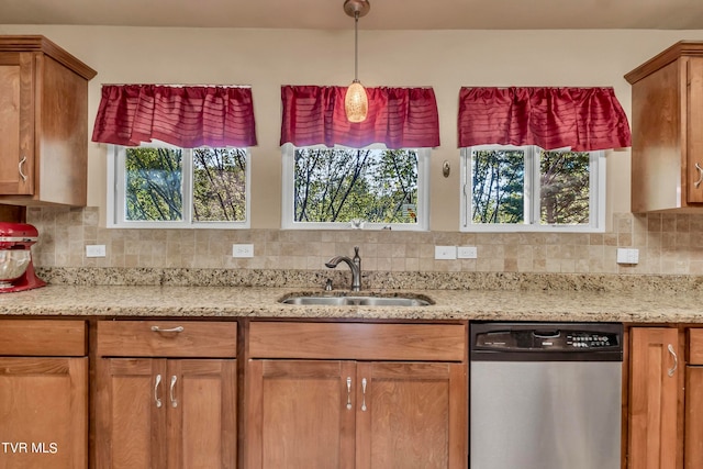 kitchen featuring backsplash, pendant lighting, sink, and stainless steel dishwasher