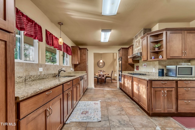 kitchen with appliances with stainless steel finishes, backsplash, ventilation hood, sink, and hanging light fixtures