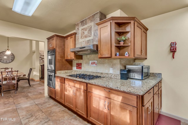 kitchen with tasteful backsplash, light stone counters, ventilation hood, stainless steel appliances, and decorative light fixtures