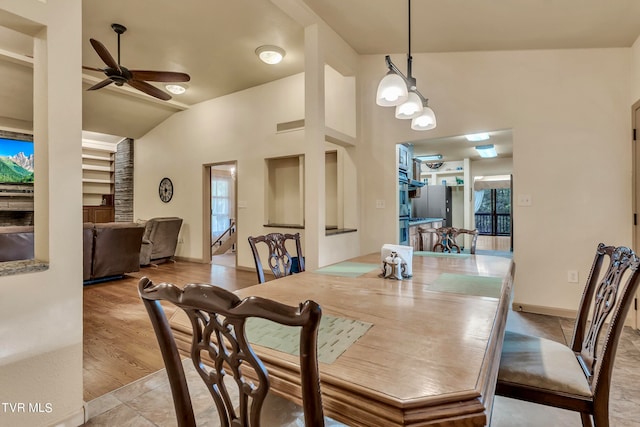 dining area featuring ceiling fan, light hardwood / wood-style flooring, and vaulted ceiling